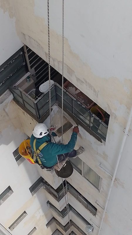 Técnico en acceso por cuerdas reparando muros de un pozo de aire y luz en Belgrano